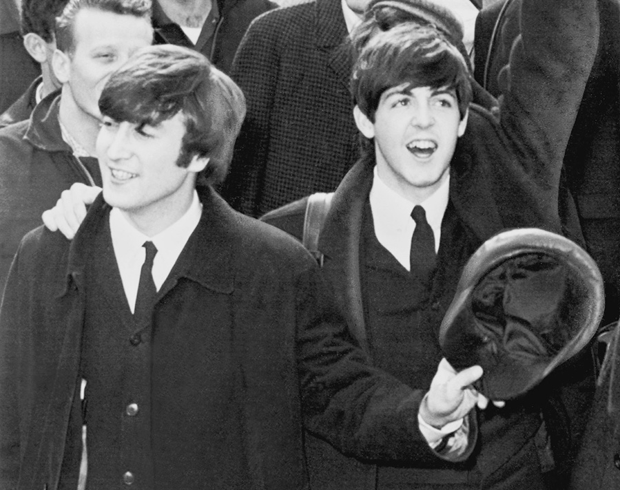 John Lennon and Paul McCartney at Kennedy Airport, 1964 (via Wikimedia Commons)